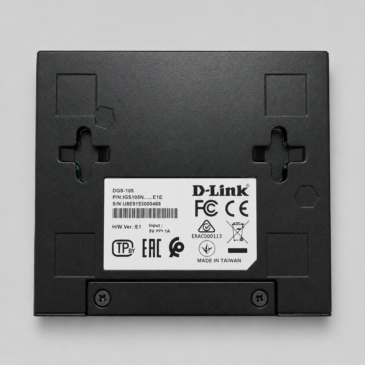 Bottom view of D-Link DGS-105 unmanaged 5 port gigabit switch showing mounting slots and product label