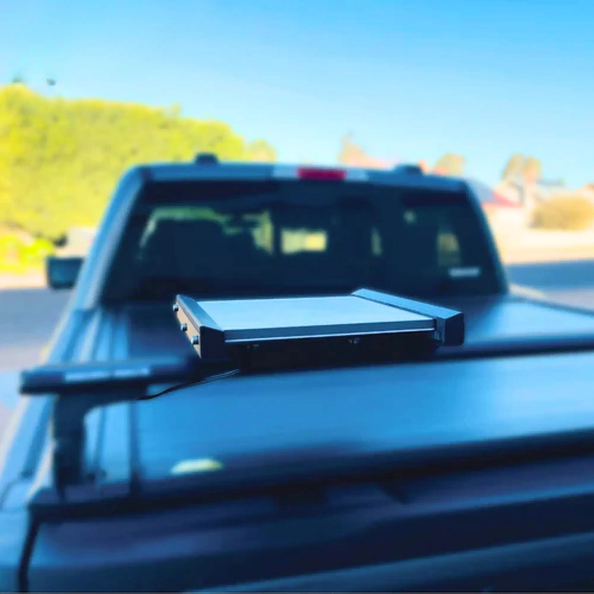 Starlink Mini in motion mount installed on a ute's tray with roof racks. 