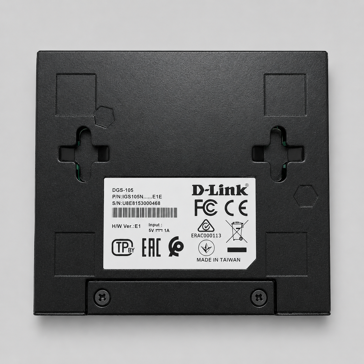 Bottom view of D-Link DGS-105 unmanaged 5 port gigabit switch showing mounting slots and product label